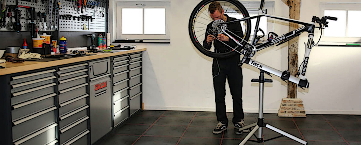 Rider MTB aggiusta la sua bici nel garage di casa