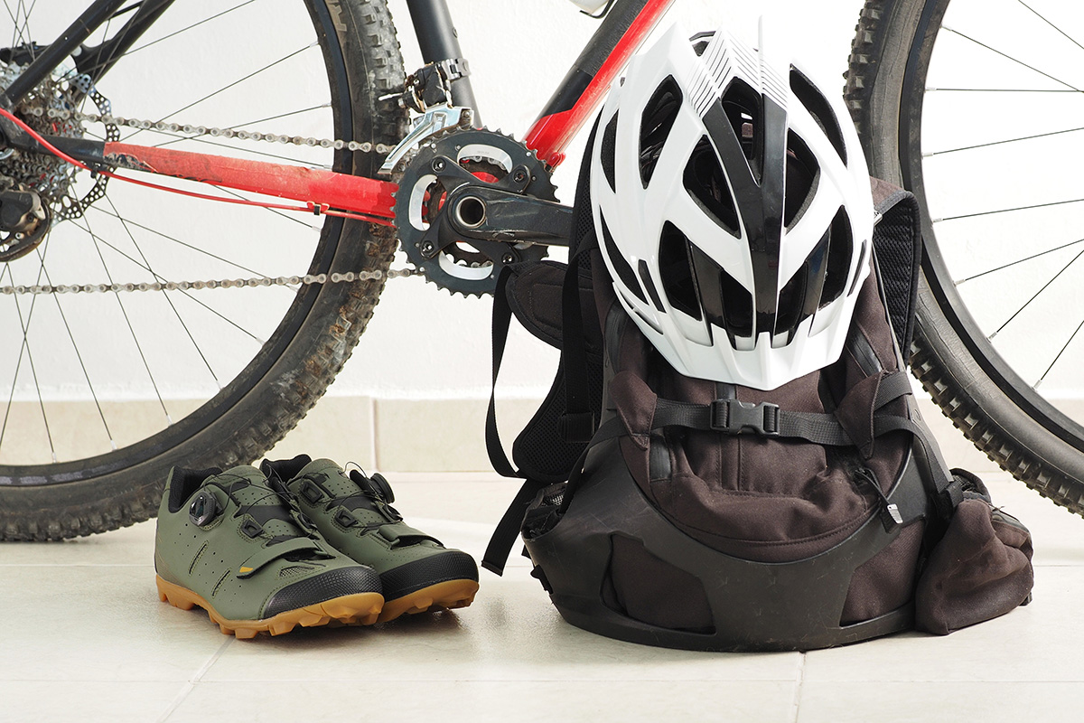 Uno zaino, un casco e delle scarpe per mountainbike