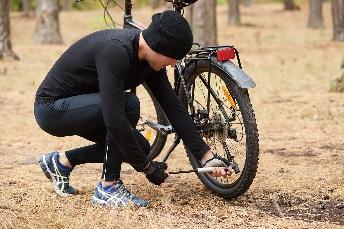 Un uomo controlla il gonfiaggio dei pneumatici della mountainbike
